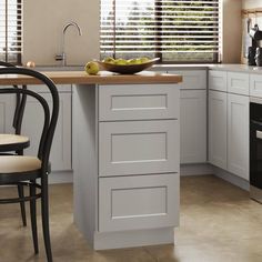 a kitchen with white cabinets and black chairs