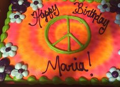 a peace sign birthday cake with flowers on it