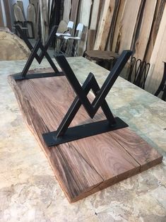 a wooden table topped with two black metal stands