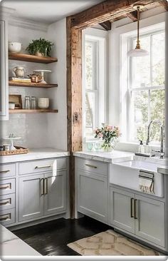 an image of a kitchen with white cabinets and wood beams on the wall, along with a rug