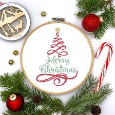 a cross stitch christmas tree with candy canes, ornaments and ornament on a white background