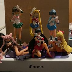 there are many figurines sitting on top of the phone stand in front of each other