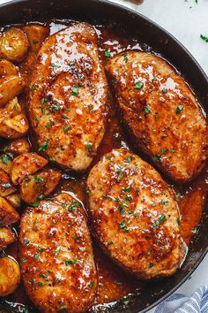 chicken and potatoes in a skillet with gravy on the side, ready to be eaten