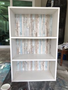 a white book shelf sitting on top of a floor