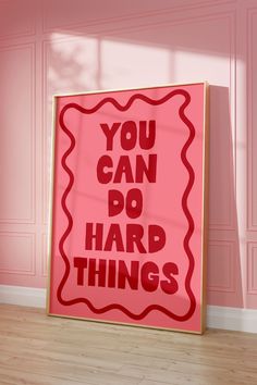 a pink poster with the words you can do hard things on it in front of a pink wall