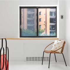 a chair sitting in front of a window next to a radiator and heater