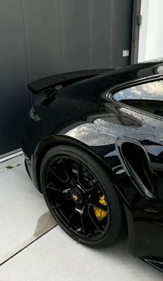 a black sports car parked in front of a garage door