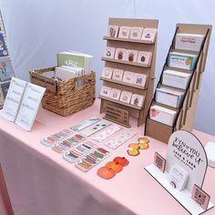 a pink table topped with lots of cards and boxes