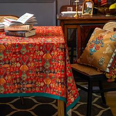 a table topped with books and pillows next to a chair