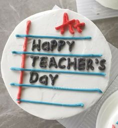 a happy teacher's day cake with red, white and blue sticks on it