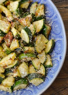 a blue and white bowl filled with cooked zucchini