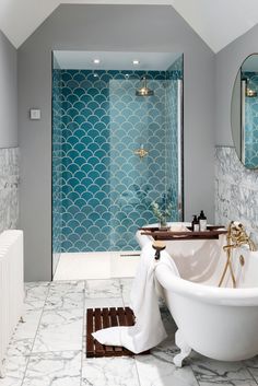 a white bath tub sitting next to a walk in shower