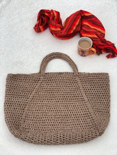 a purse, scarf and coffee cup sitting on the ground