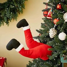 a christmas tree decorated with stockings and ornaments, including a santa clause ornament