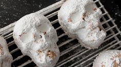 powdered sugar covered donuts cooling on a rack