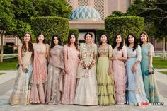 a group of women standing next to each other in front of a building