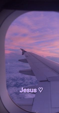 an airplane wing with the word jesus written on it in front of a sunset sky