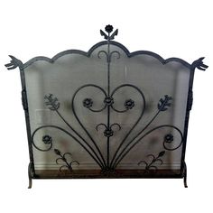 an ornate iron fireplace screen with flowers and leaves on it's sides, set against a white background