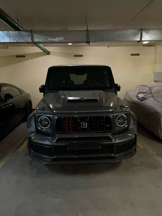 two cars parked in a parking garage next to each other on the floor and one is black