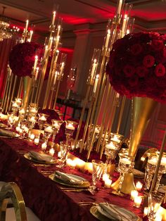 a long table with candles and flowers on it is set for a formal dinner or reception