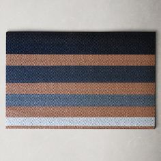 a brown and blue striped placemat on a white surface