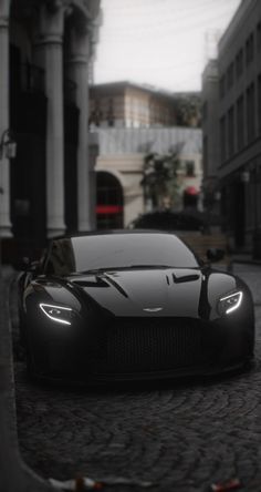 a black sports car parked in front of a building on a cobblestone street