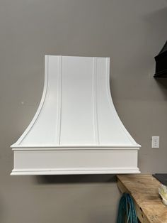 a white range hood mounted on the wall