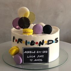 a white cake with lots of colorful candies on top and a sign that says friends