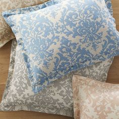 four pillows stacked on top of each other with blue and white designs in the middle