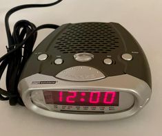 an alarm clock radio sitting on top of a white table next to a black cord