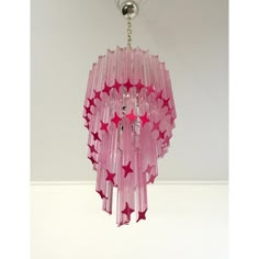 a pink chandelier hanging from a ceiling with stars on the top and bottom