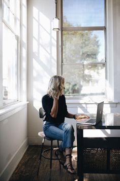 a woman sitting at a desk using a laptop computer