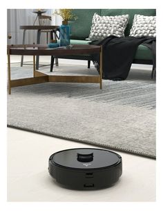 a roomba that is on the floor in front of a couch and coffee table