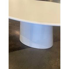 an oval white table sitting on top of a tiled floor