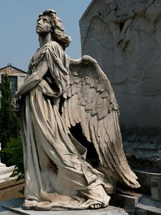 an angel statue sitting in front of a monument