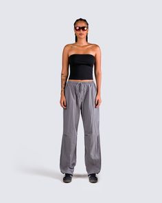 Give off a vibe that everyone will want more of in this 2 piece set 😌 This effortless baddie fit features a black jersey tube top and a pair of grey parachute pants for the perfect everyday look 🖤 Summer Stretch Parachute Pants For Streetwear, Summer Streetwear Stretch Parachute Pants, Sporty Summer Parachute Pants For Streetwear, Sporty Parachute Pants For Summer Streetwear, Gray Techwear Parachute Pants For Streetwear, Casual Parachute Pants For Workout, Sporty Nylon Parachute Pants For Loungewear, Nylon Parachute Pants For Loungewear, Gray Relaxed Fit Activewear For Streetwear