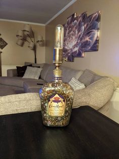 a bottle of liquor sitting on top of a wooden table in front of a couch