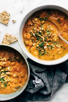 two bowls filled with soup next to crackers