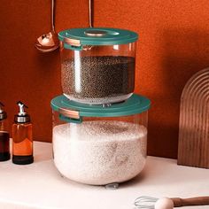 a bird feeder sitting on top of a counter next to some bottles and spoons