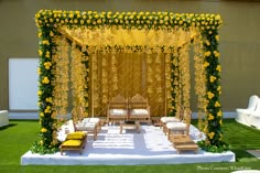 an outdoor wedding setup with yellow flowers and greenery