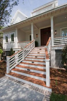 a white house with wooden steps leading up to the front door