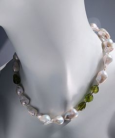 Immerse yourself in the allure of nature with our captivating "Summer in Peridot" necklace, a versatile piece designed to be cherished all year round! Adorned with exquisite baroque pearls and radiant peridot gemstones elegantly set amidst 14 Karat gold beads, this necklace is finished with a luxurious 14 Karat gold hook and eye clasp. Featuring a unique touch of sophistication, the peridots are artfully offset on both sides of the necklace, adding a hint of elegant whimsy to this timeless creat Elegant Green Baroque Pearl Necklace, Glow Jewelry, Peridot Earrings, Peridot Necklace, Semi Precious Gems, Baroque Pearl Necklace, Pearl Collection, Peridot Gemstone, Gold Collection