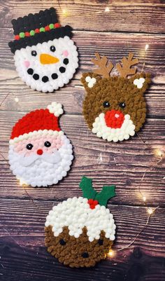 four christmas ornaments made out of crochet on a wooden table