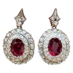 Victorian Ruby and Antique Diamond Drop Earrings measuring .90 x .50 inches. These earrings are gorgeous and unique and are an excellent asset for your wardrobe—double rows of diamonds accent beautiful ruby center stones on a dangle drop earring. Thirty-six antique round diamonds are set in a double bezel around the center ruby. The diamonds are single, rough cuts The metal is a silver Ruby gemstones: Two Oval shaped measuring 8.62 x 5.83 x 2.50 mm with an estimated weight of 2 carats total The Princess Cut Earrings, Art Deco Drop Earrings, Diamond Cluster Earrings, Platinum Earrings, Diamond Dangle Earrings, Silver Tops, Ruby Jewelry, Art Deco Earrings, Princess Diamond