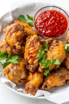 chicken wings with parsley and ketchup on a white plate