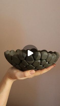 a person holding a bowl with rocks in it