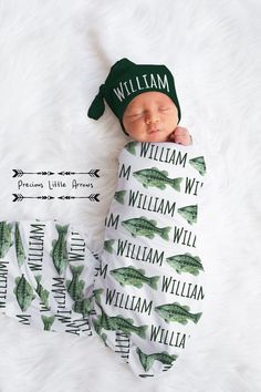 a newborn baby wrapped in a green hat and sleeping on a white furnishing