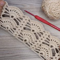 someone crocheting yarn on a table next to two balls of yarn