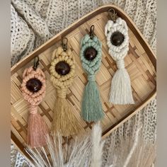 four tasselled key chains on a woven tray