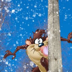 a cartoon character hanging from a pole with snow falling on the ground and trees in the background